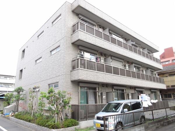 緑の植栽をふんだんに使ったアプローチ 落ちついた外観にマッチしたエントランス