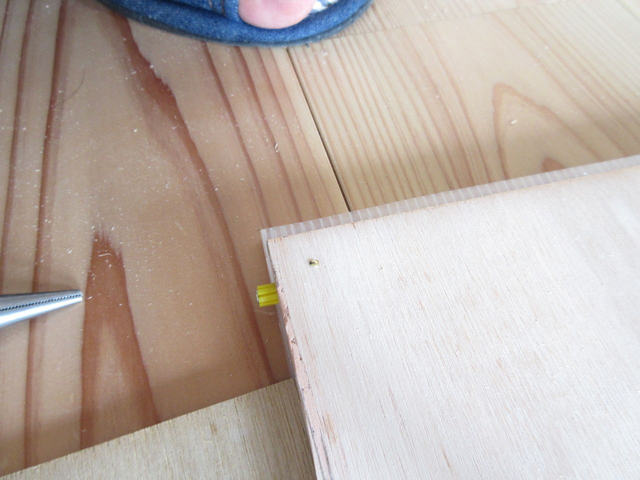 木枠材をベニヤ板に接着剤で固定しましたが、それだけではちょっと不安だったので仕上げ面に真鍮釘を打ち込みました。
この真鍮釘ですが、小さいので遠くから見る目立ちません。
しかし、近くで見ると意外と良い感じにベニヤ板と合っていて可愛らしく、ちょっとしたアクセントになっています。