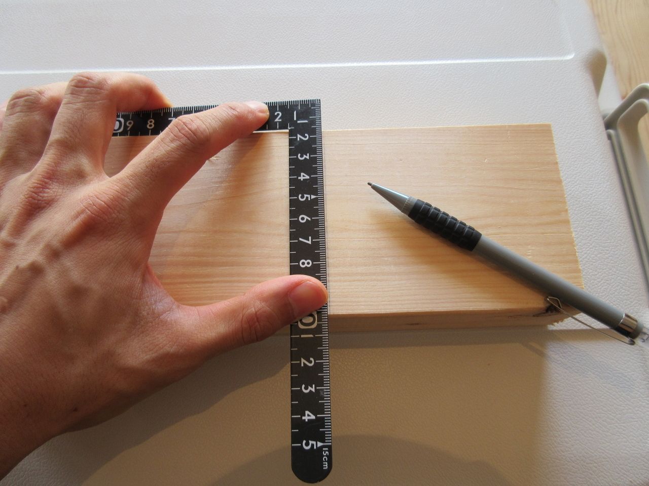 サシガネを使えば木材に対して直角な線を引きます。木材にサシガネを引っ掛けて、鉛筆などで線を引けば完了です。状況にもよりますが、サシガネの長手（長い方）側を木材に当てて、妻手（短い方）側で線を引いた方がより正確な直角の線が引けます。
