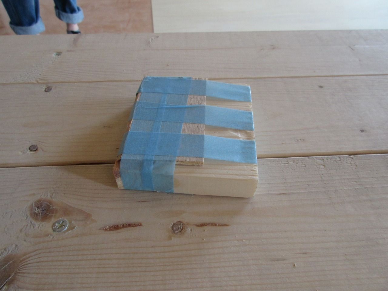 余っていた1×4(ワンバイフォー)材とベニヤ板を小さくカットして、マスキングテープでぐるぐる巻きにしただけです。
これを隙間ができている部分のベニヤ板の上に乗せて、隙間に差し込むだけです。